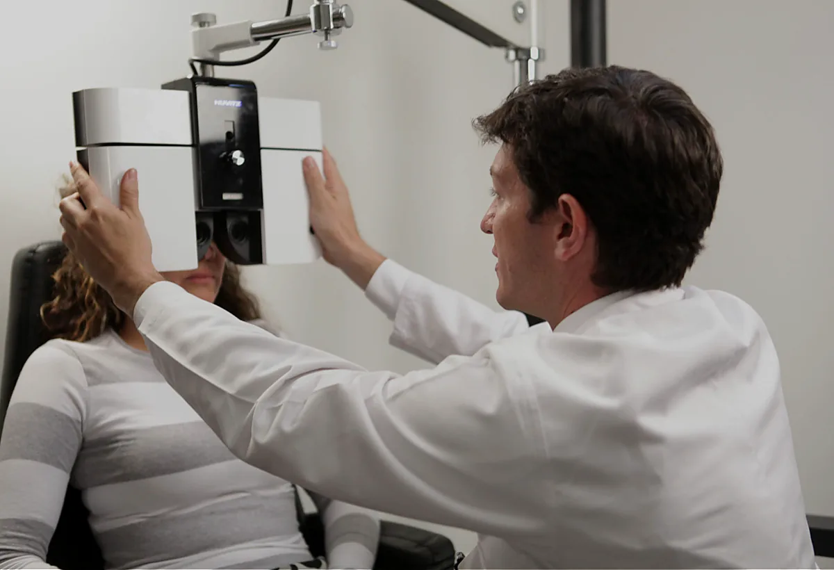 Dr. Juan Pablo Aparicio realizando un examen ocular a una paciente